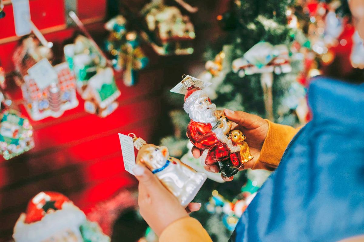 Child decides between two holiday ornaments while Christmas shopping