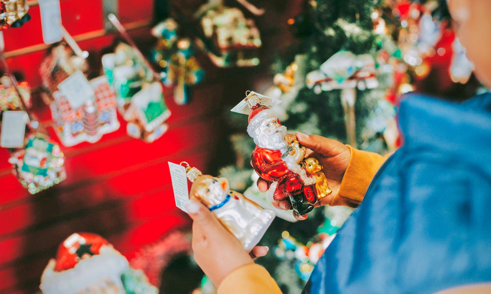 Child decides between two holiday ornaments while Christmas shopping