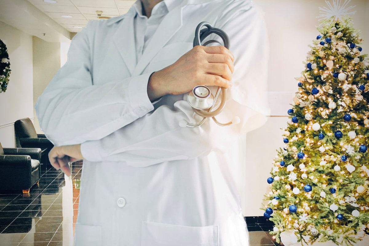 Hospital Reception Area with large Christmas Tree. Doctor is standing in front during the holiday season. Christmas Wreath on wall in back.