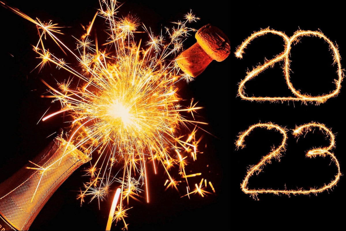 2023 Written in Lights with Sparks flying out from a popped bottle of champagne to celebrate New Year's Eve!